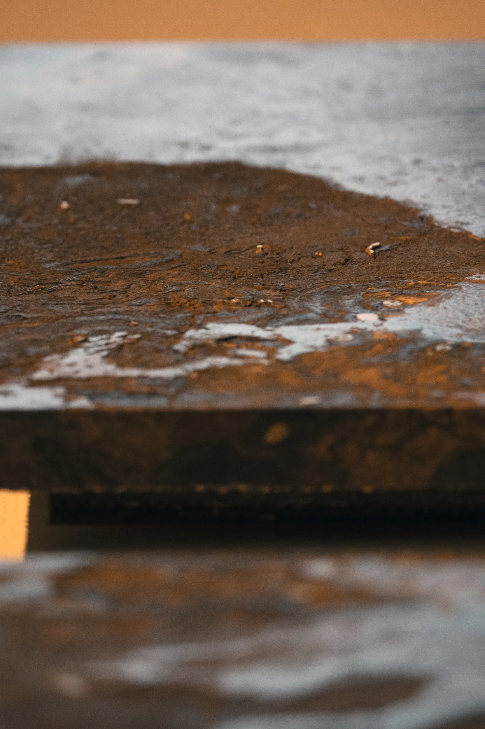 A detailed view of 'All Downhill From Here' (2022 - 2047), A painting from Damian Boylan's Acid Paintings series, where acid is progressively painted on to a marble substrate, over a 10 year period, to progressively erode the underlying material.