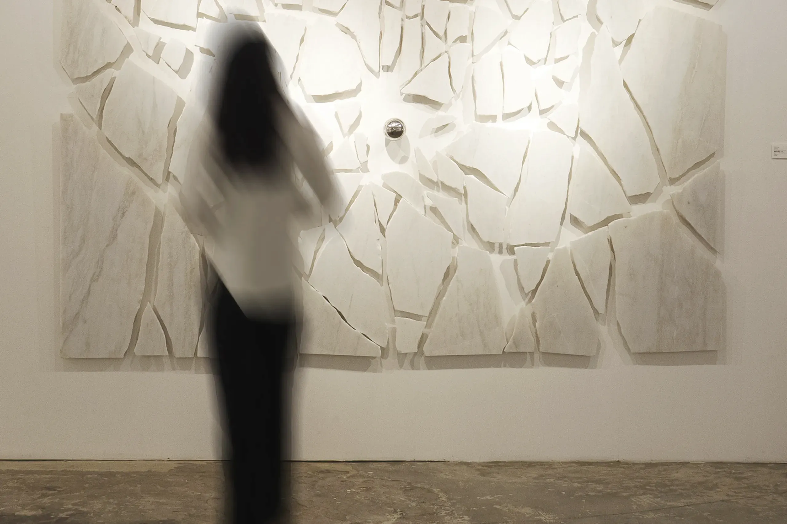 An installation view of 'Libration' (2023), A painting from Damian Boylan's Acid Paintings series, where acid is progressively painted on to a marble substrate to progressively erode the underlying material.